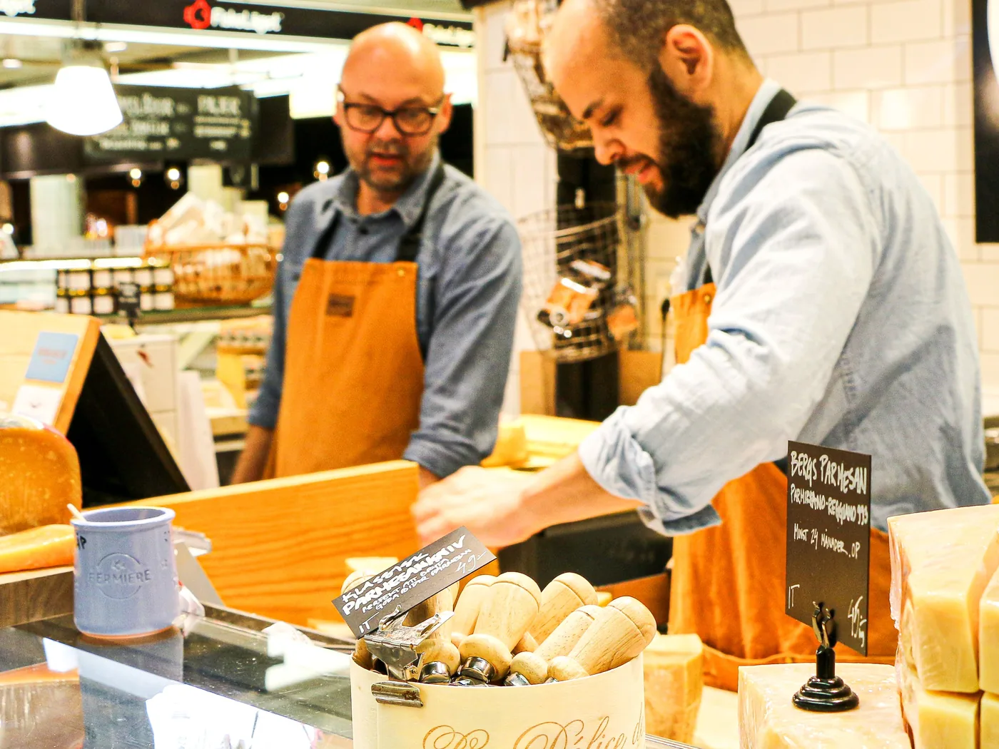 Deux fromagers préparent une commande derrière leur comptoir