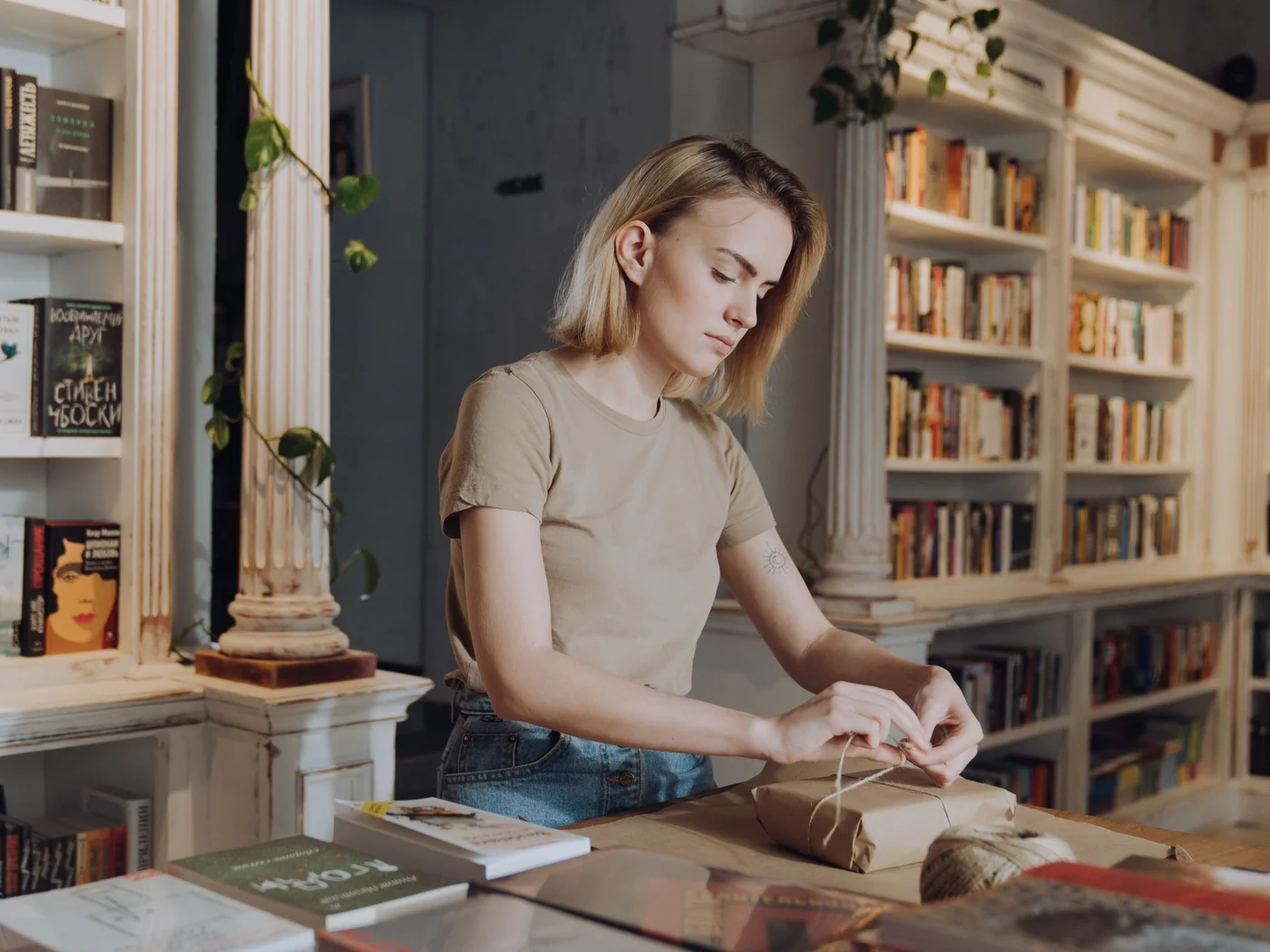 Une libraire emballe un livre sur le comptoir de sa librairie
