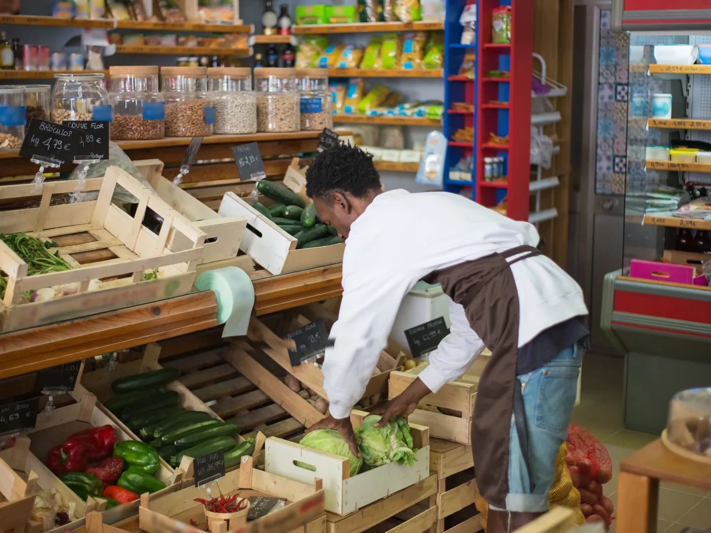 Un primeur range des caisses de légumes sur son étal